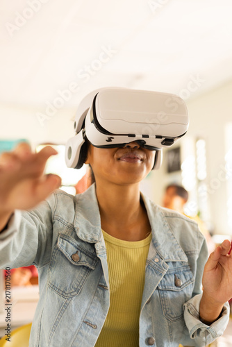 Using VR headset, teenager exploring virtual reality in high school classroom