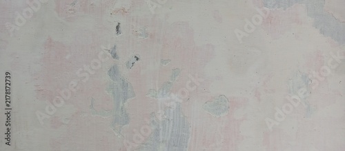 Worn off white plaster wall with pinkish stains