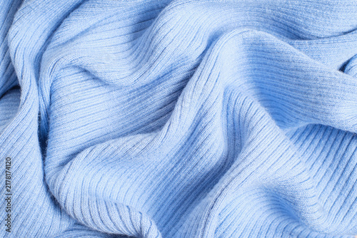 Crumpled texture of blue knitted fabric close-up top view.