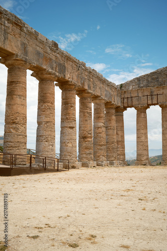 Vertical interior view of long Doric colonnade meeting corner entablature in Segesta, Sicily, Italy