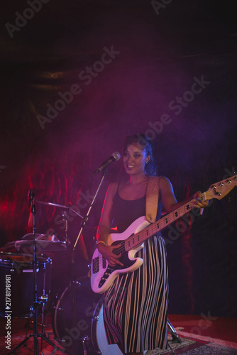 Musician playing electric guitar on stage, enjoying live performance with band, copy space