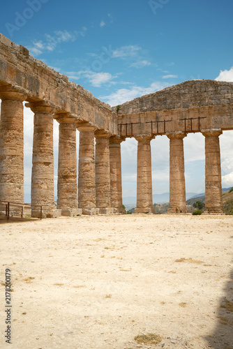 Vertical low-angle interior view of Doric colonnade and corner pediment under blue sky in Segesta, Sicily, Italy