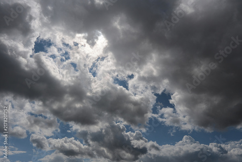 Stratocumulus Dramatic Dark Storm Clouds with Sunlight Breaking Through Over Blue Sky