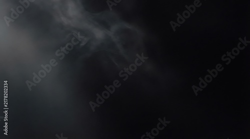 Dark smoke swirling against a black background atmospheric haze and vapor texture