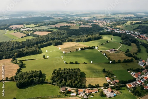 Aerial view of green rice field with land plot boundary and location pin icon for real estate investment