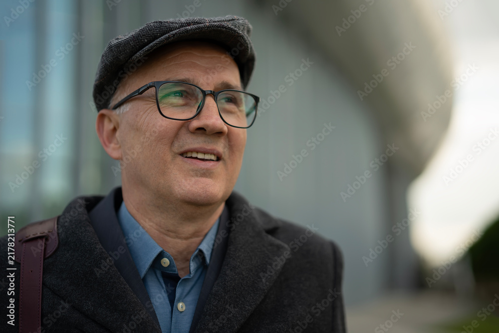 Fototapeta premium Mature man in flat cap looking upwards