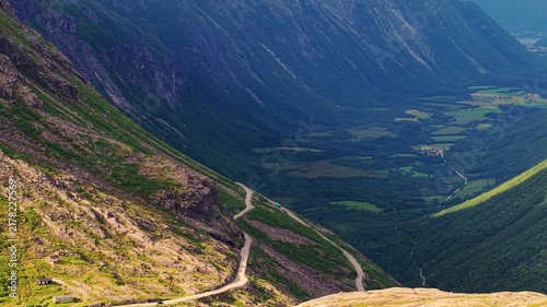 Aerial perspective looking down the dramatic Trollstigen valley, showcasing steep mountain walls and the hairpin road in Rauma, Norway