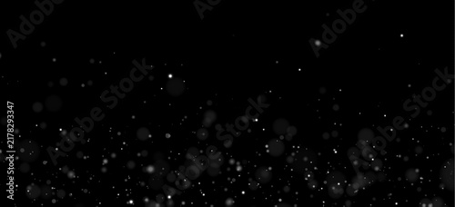 Soft bokeh particles float across a dark background in varying sizes and opacities. The scattered dots create a gentle, glowing effect with subtle intensity shifts.