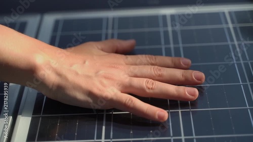 Human hand touching a modern residential solar panel