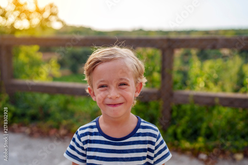 Canvastavla Happy blonde boy wearing a striped shirt and smiling at the camera, portraying i