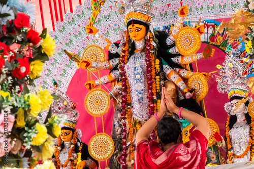 young women Devotee Praying Before Grand Goddess Durga Idol at Hindu dussehra Festival