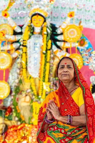Hindu old age Woman devotee Praying Before Goddess Durga Idol During Durga Puja Festival