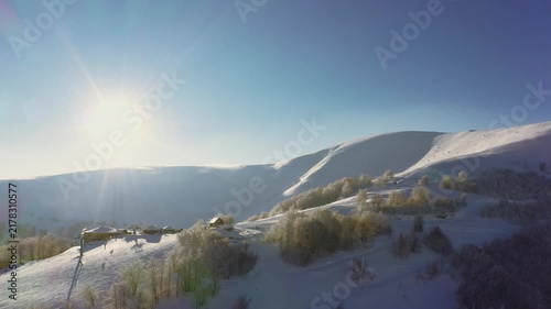 Old ski station on a snowy mountain slope with a lot of people on skis and snowboards