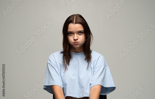 Quadro su tela Young woman puffing cheeks with a playful, annoyed, or bored expression, creatin