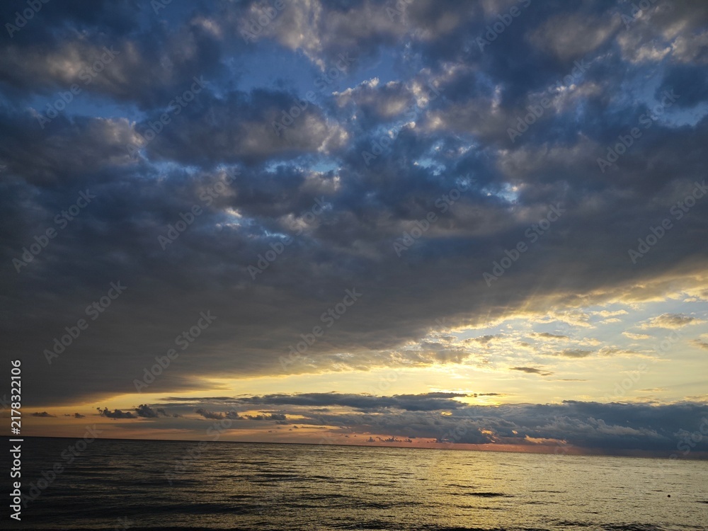 Foto Dramatic sunset sky with heavy clouds over the sea