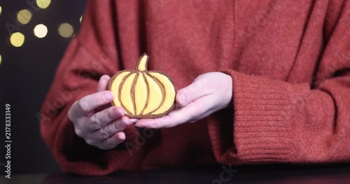 Pumpkin cookies in a woman's hands for Halloween
