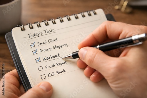 Person checking off tasks on a to-do list with a pen small daily wins