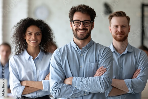 Smiling diverse business team standing with folded arms together in a bright modern office space