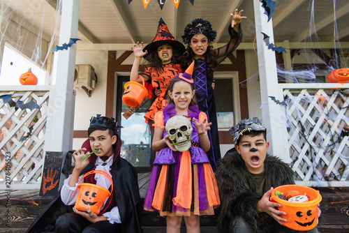 Obraz na płótnie Cute kids in creative Halloween costumes enjoying a spooky fun time on a festive