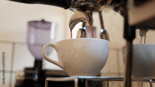 Close-up of espresso pouring from the coffee machine into a coffee cup. Professional coffee brewing	