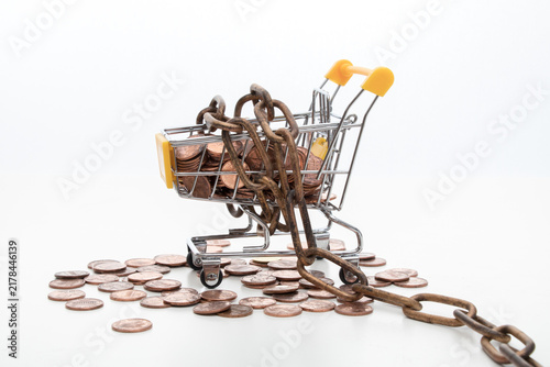 Foto Chained shopping cart with coins symbolizing debt and financial restriction