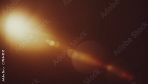 Obraz na płótnie Warm lens flare and light leak background with soft bokeh glow and dark brown tones, cinematic abstract texture for photography, posters, overlays and digital design