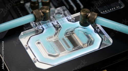 Custom liquid cooling water block on a high performance computer motherboard with blue coolant