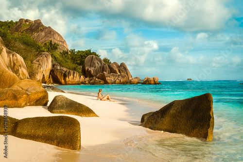 Senior woman relaxing on white sand at Anse Source d'Argent Beach, La Digue, Seychelles
