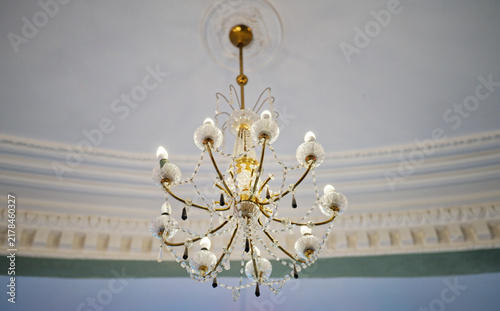 Photography Close-up of illuminated decorative chandelier with gold-tone frame and crystal e