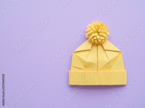 Creative Yellow Paper Origami Beanie Hat with Pom Pom on Purple Background for Craft Lovers