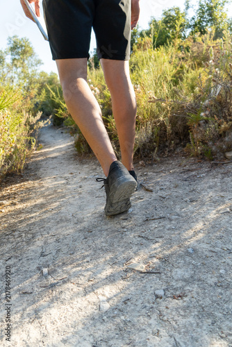 Canvastavla Person's legs walking along a dusty trail, exploring nature and enjoying a healt