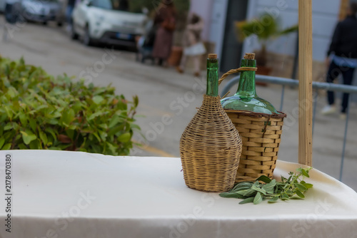 Foto Mosciano Sant'Angelo, Italy - October 26, 2025: Traditional glass wine demijohns in wicker baskets