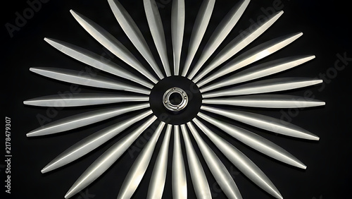 Circular arrangement of polished silver metal blades radiating from a central hub.