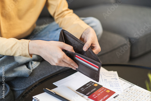 Obraz na płótnie debts in first jobber, Young woman open wallet find it empty with many invoice and credit card on the table
