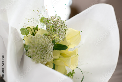 Wedding bouquet with golden rings on a black table. Soft natural light, calm morning atmosphere, bridal preparation concept.
