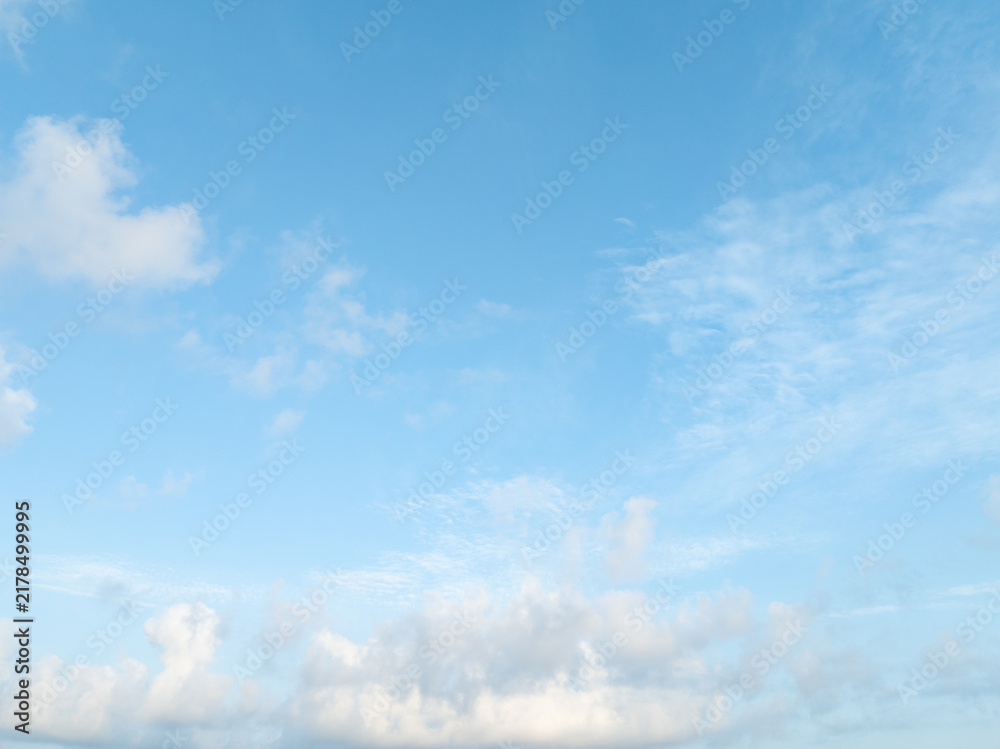 Obraz premium Bright blue tropical sky with soft white cumulus clouds during calm morning weather. Spacious natural background for environmental, seasonal design, weather, climate, nature, wellness concepts.