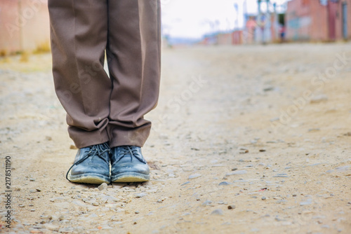Dirty black shoes belonging to a boy in a school uniform in La Paz, Bolivia - Concept of Education