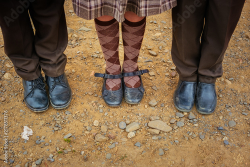 Three children in school uniforms wearing black shoes on the ground in La Paz, Bolivia - the concept of education