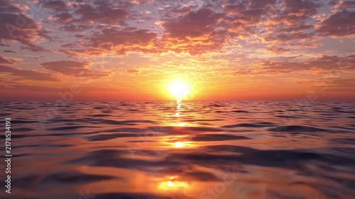 Sunlight reflects over rippling ocean waves during a vibrant golden hour sunset at the horizon with video captures sun setting over ocean golden light reflecting moving water surface