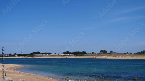 panoramic view of sandy beach bay with calm blue ocean and clear sky