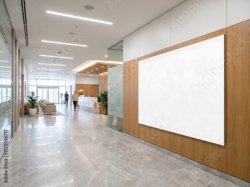 Modern office lobby interior with a large blank white sign on a wooden wall.