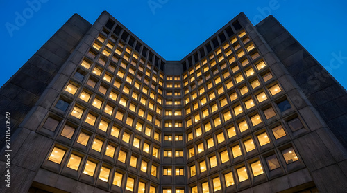 Modern corporate building corner with glowing windows at night.