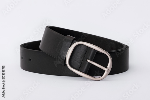 Black smooth leather belt coiled with a rounded silver buckle on a white background