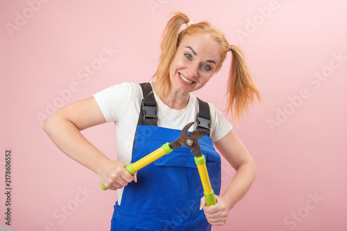Bild auf Leinwand Cheerful young woman wearing blue overalls and a white t shirt, smiling and hold