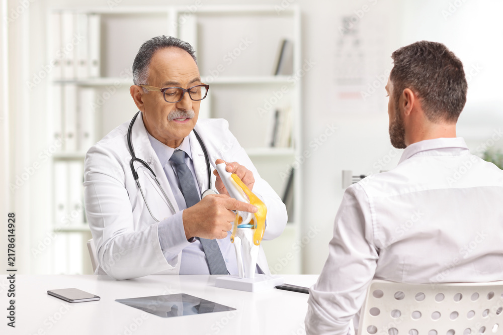 Fototapeta premium Doctor discussing a knee problem with a patient