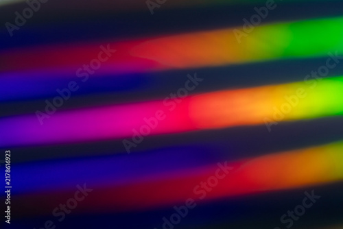 Colorful rainbow light bands blurred into diagonal stripes create a vibrant a...