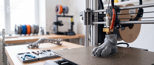 Obraz na płótnie Desktop 3d printer producing foot prototype in modern makerspace workshop with tools and filament