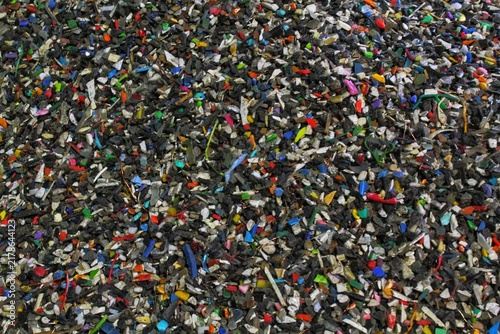 Full frame texture of crushed multicolored plastic and electronic waste secondary raw material pile presenting e-waste processing recycling industrial ecology environmental protection concept