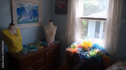 with fabric scraps tangled threads needles stuck randomly and mannequins tilted