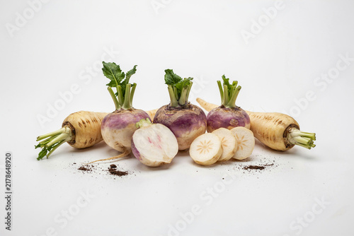Fresh purple rutabagas and carrots on a rustic surface